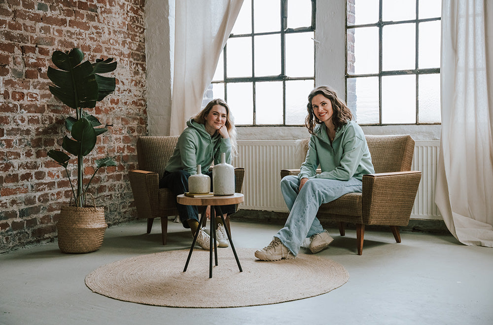 Sophia und Lena in einer Sitzecke mit mosja Hoodie und Halz-Zip in Mint
