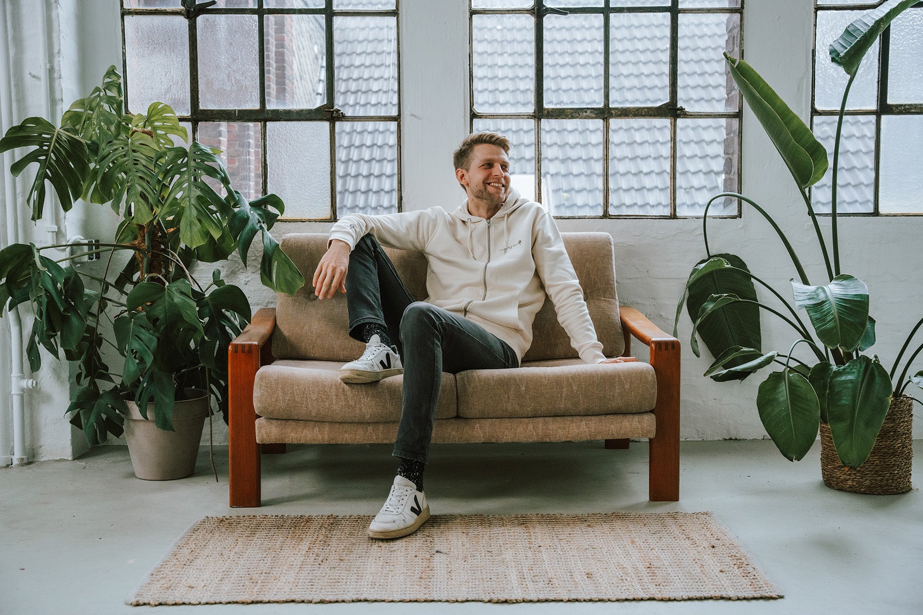 Samuel mit unserem Zip Hoodie Nature auf einem Vintage Sofa